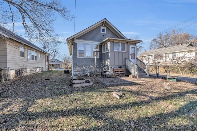 view of front of house featuring board and batten siding and fence