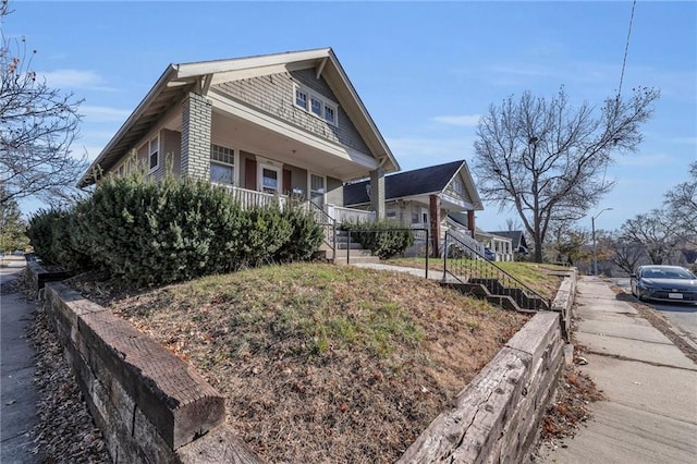 view of home's exterior with covered porch and stairs