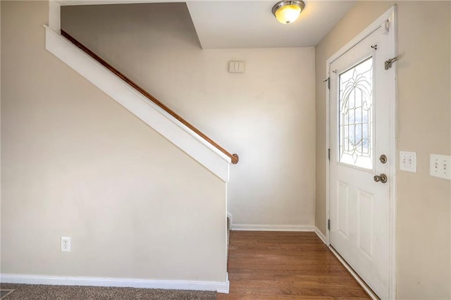 foyer entrance featuring stairs, baseboards, and wood finished floors