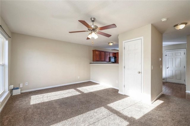 unfurnished living room with ceiling fan, carpet flooring, visible vents, and baseboards