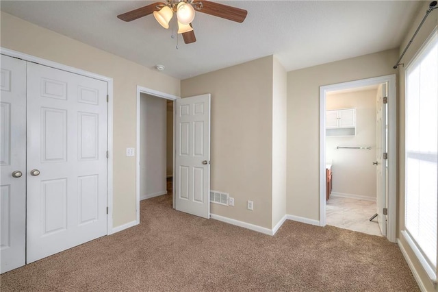 unfurnished bedroom with ceiling fan, carpet floors, visible vents, and baseboards