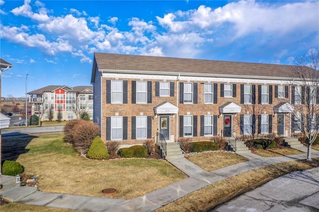 view of front facade with a front yard and brick siding