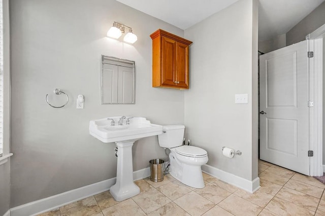 bathroom with toilet, baseboards, and tile patterned floors