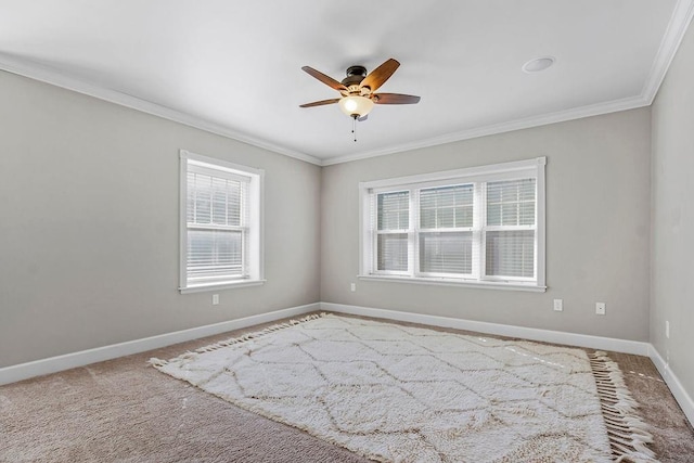 carpeted empty room with crown molding, baseboards, and ceiling fan