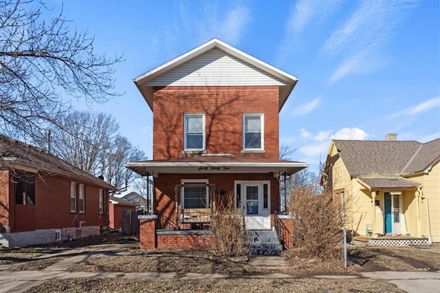 view of front facade featuring a porch and brick siding