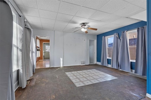 spare room featuring a ceiling fan, a paneled ceiling, visible vents, and baseboards