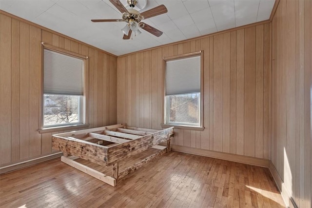 unfurnished bedroom featuring wood-type flooring, ceiling fan, and baseboards