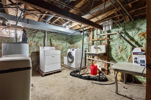 unfinished below grade area featuring washing machine and dryer, water heater, and a sink