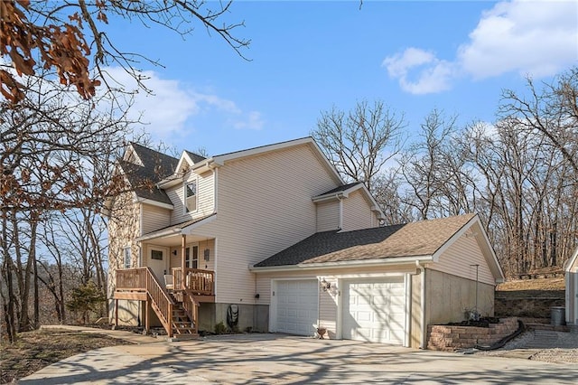 view of home's exterior with stairway, roof with shingles, concrete driveway, and an attached garage