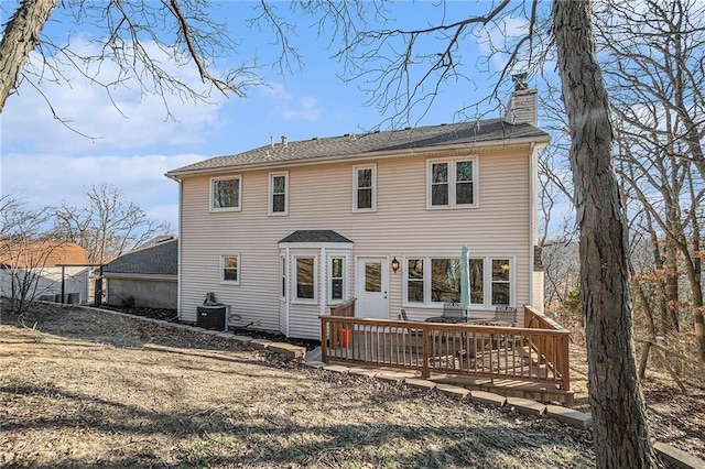 rear view of property featuring a wooden deck, central AC unit, and a chimney