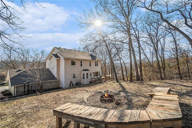 rear view of house featuring a chimney and a fire pit