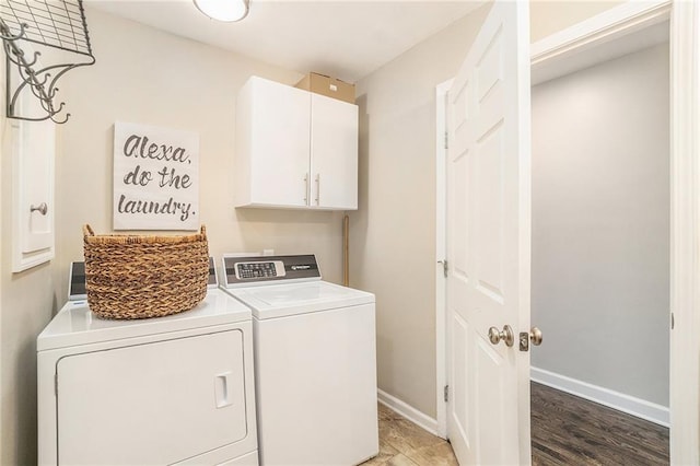 washroom with washer and dryer, baseboards, and cabinet space