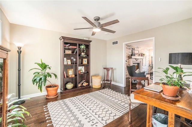 office area with wood finished floors, a fireplace, visible vents, and baseboards