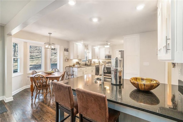 dining space featuring ceiling fan with notable chandelier, recessed lighting, baseboards, and dark wood-style flooring