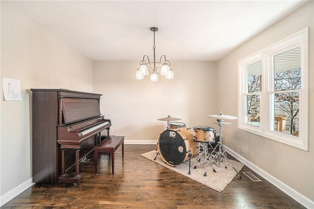 recreation room with dark wood-type flooring, visible vents, baseboards, and a chandelier