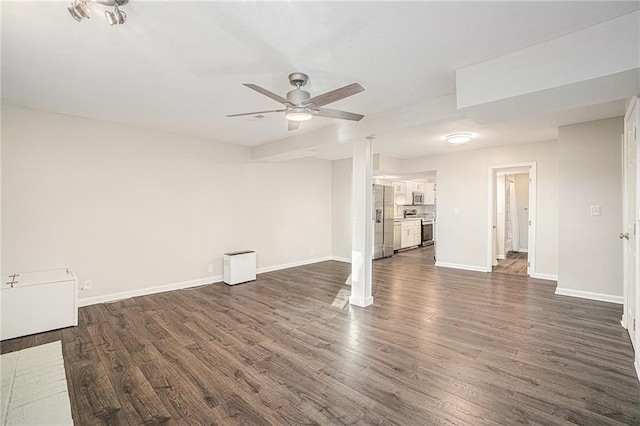 unfurnished living room featuring baseboards, dark wood-type flooring, and ceiling fan