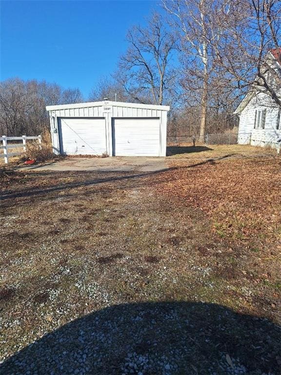 detached garage featuring fence