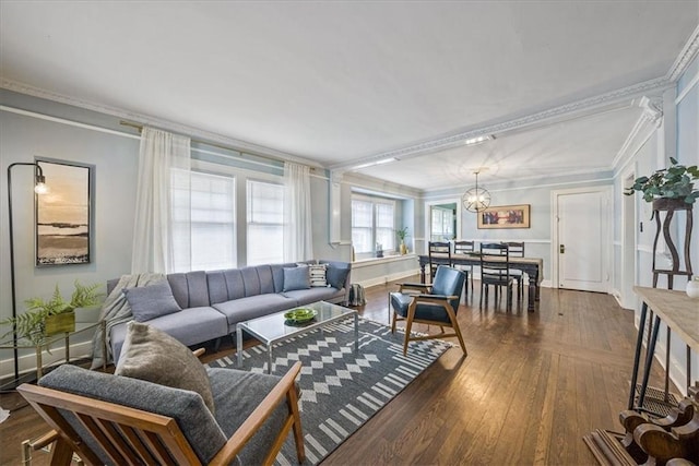 living room with dark wood-style floors, a notable chandelier, baseboards, and crown molding