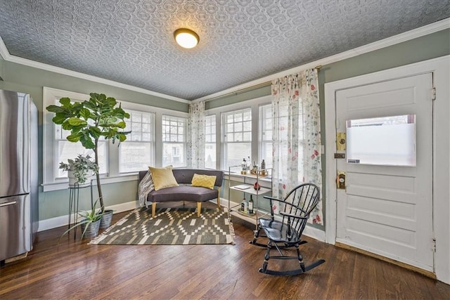 living area featuring an ornate ceiling, crown molding, baseboards, and wood finished floors