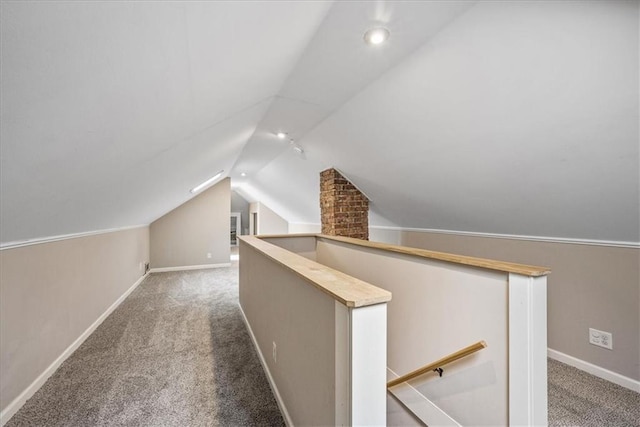 additional living space featuring vaulted ceiling, carpet, and baseboards