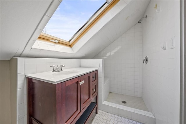 bathroom with lofted ceiling with skylight, a shower stall, and vanity