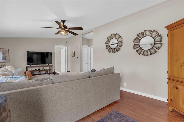 living area with lofted ceiling, ceiling fan, baseboards, and wood finished floors