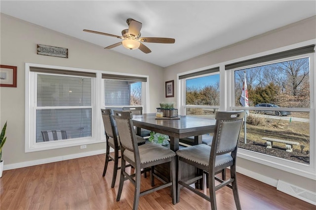 dining area featuring vaulted ceiling, wood finished floors, visible vents, and baseboards