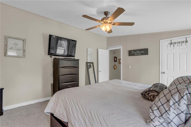 carpeted bedroom with a ceiling fan and baseboards