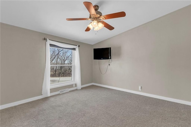 spare room featuring carpet, visible vents, lofted ceiling, and baseboards