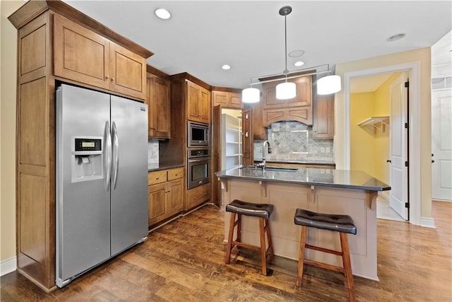 kitchen featuring stainless steel appliances, dark wood finished floors, a sink, and tasteful backsplash