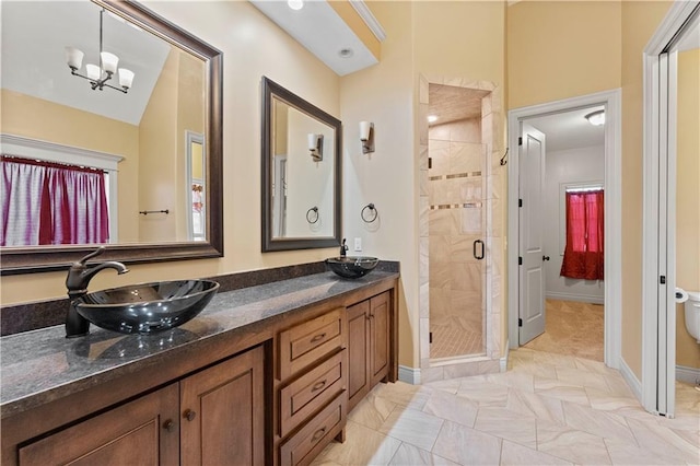 full bath with baseboards, a notable chandelier, a shower stall, and vanity