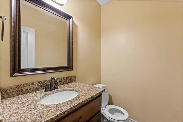 half bathroom with vanity and toilet