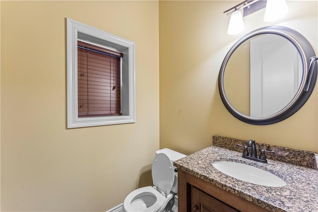 half bathroom featuring vanity and toilet