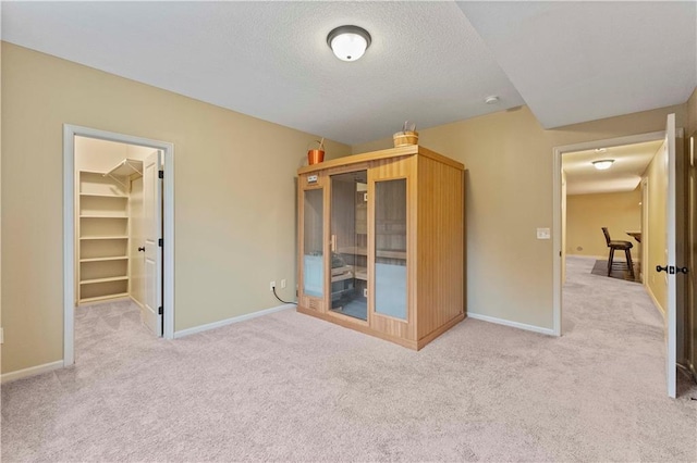 unfurnished bedroom featuring carpet floors, a spacious closet, and baseboards