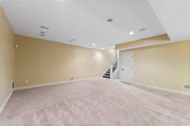 empty room featuring baseboards, visible vents, light colored carpet, stairway, and recessed lighting