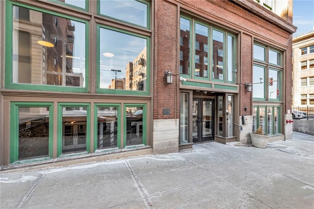 property entrance featuring brick siding and french doors