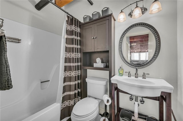 bathroom featuring toilet, shower / tub combo, and a sink