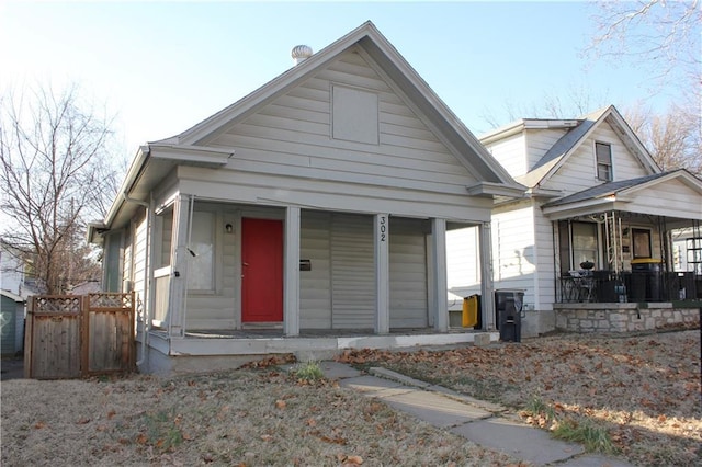 bungalow-style home featuring a porch and fence