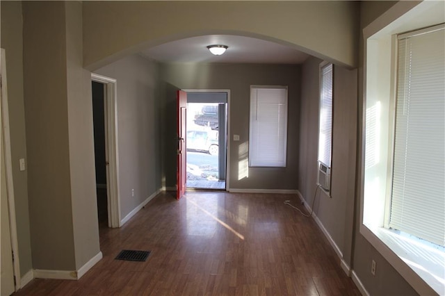 foyer featuring visible vents, arched walkways, and baseboards