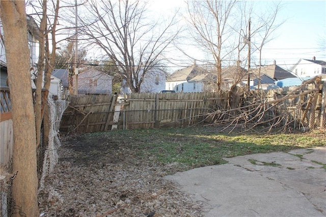 view of yard featuring a patio, fence, and a residential view