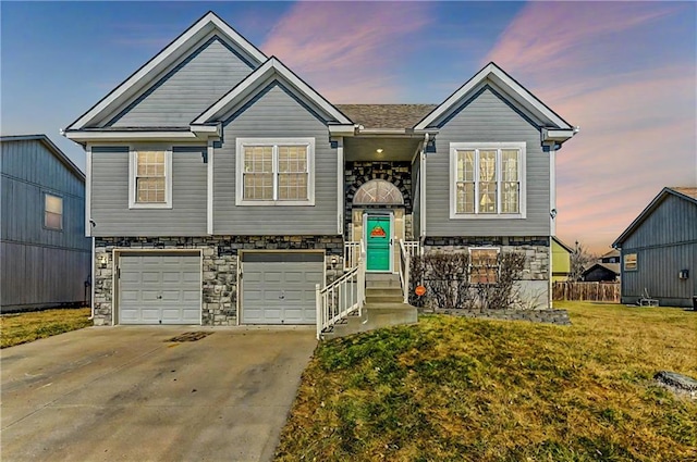 bi-level home featuring concrete driveway, stone siding, an attached garage, fence, and a front lawn