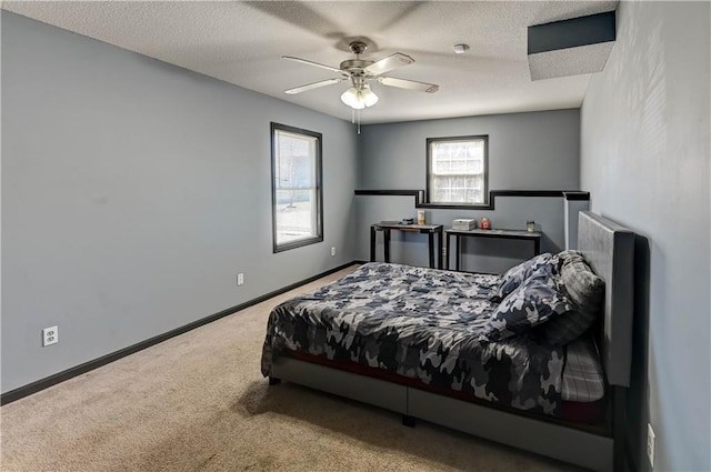 carpeted bedroom featuring ceiling fan, a textured ceiling, and baseboards