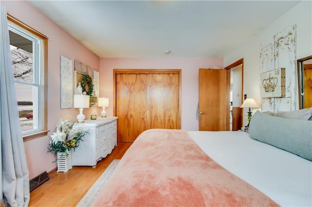 bedroom featuring light wood finished floors and a closet