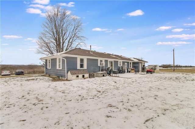 view of snow covered back of property