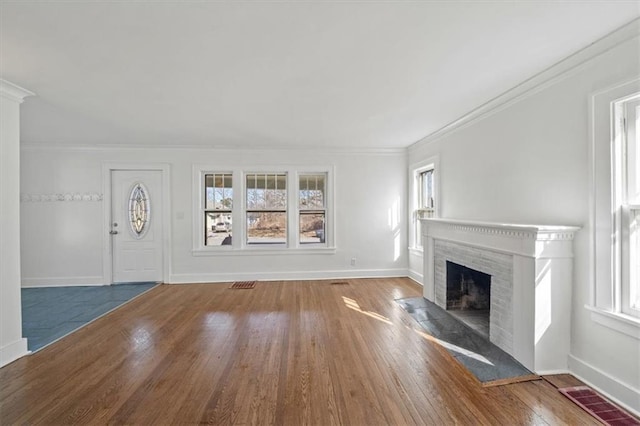 unfurnished living room featuring visible vents, a fireplace with flush hearth, hardwood / wood-style flooring, and baseboards