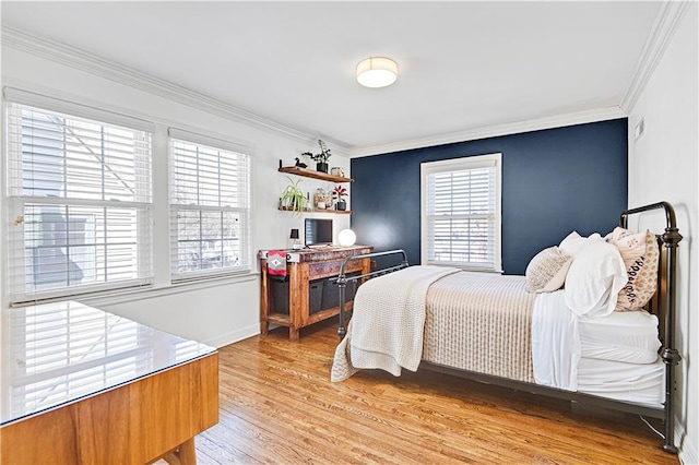 bedroom with light wood finished floors, baseboards, and crown molding