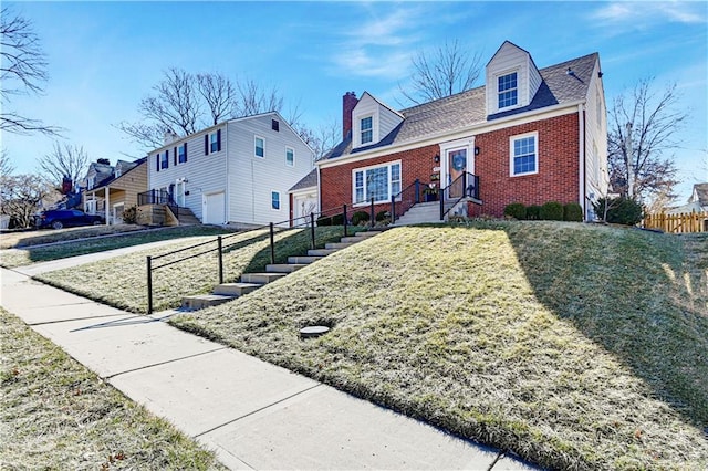 cape cod home with a front yard, brick siding, and fence