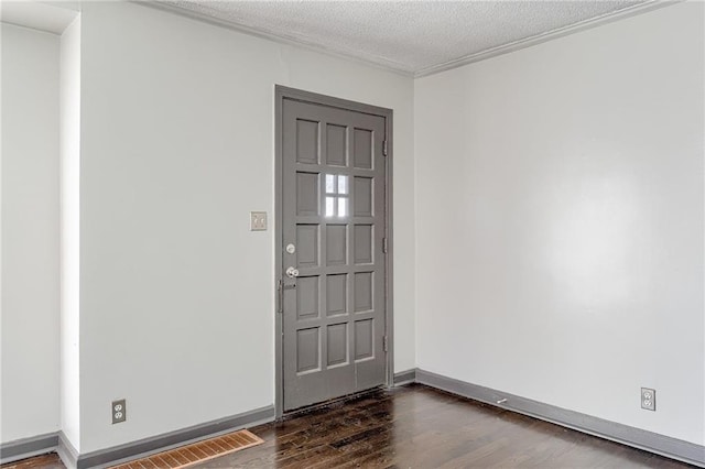 unfurnished room with a textured ceiling, dark wood finished floors, and baseboards