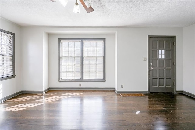 entrance foyer with a textured ceiling, baseboards, and wood finished floors