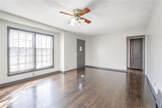 empty room with ceiling fan, baseboards, and wood finished floors